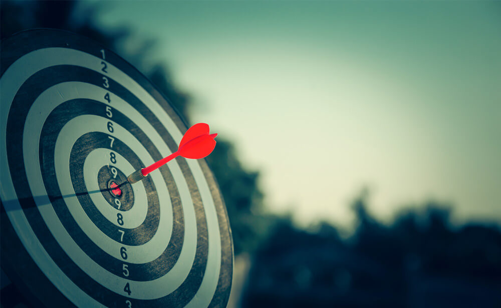 A black and white image depicting a bullseye. In the center of the bullseye is a red dart, symbolizing precision and focus. This image represents the concept of operating principles as guiding targets for organizational success, emphasizing clarity, alignment, and adherence to core values.