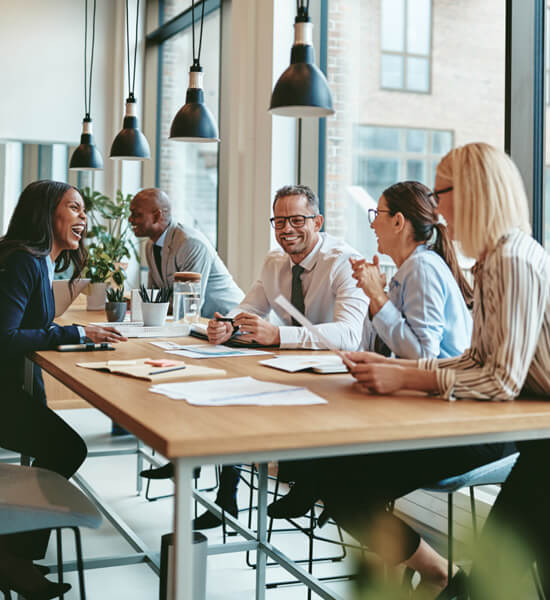 A group of business professionals seated at a conference table facilitating a meeting.